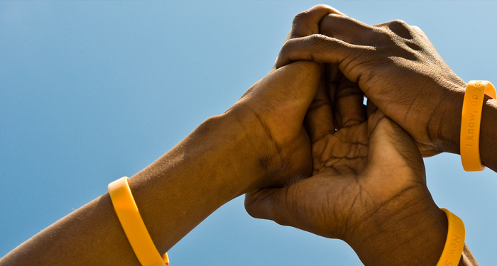 Three men joining hands.